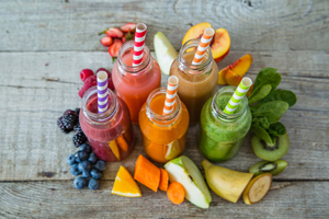 Selection of colourful smoothies on rustic wood background